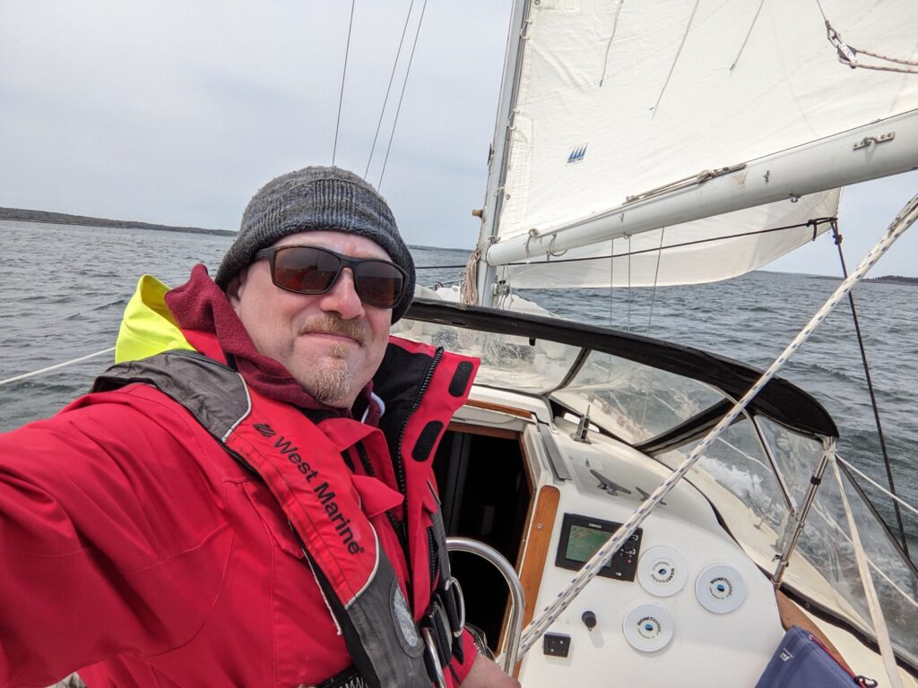 Greg Tremblay bundled up against the cold aboard his boat under sail